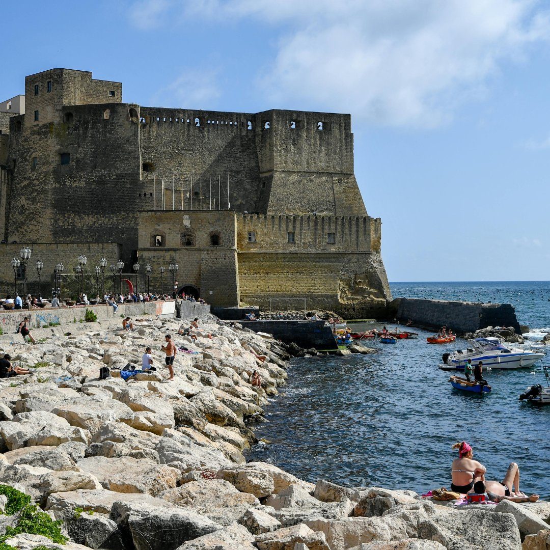 Castel dell'Ovo seaside fortress and the small boats of Borgo Marinari in Naples