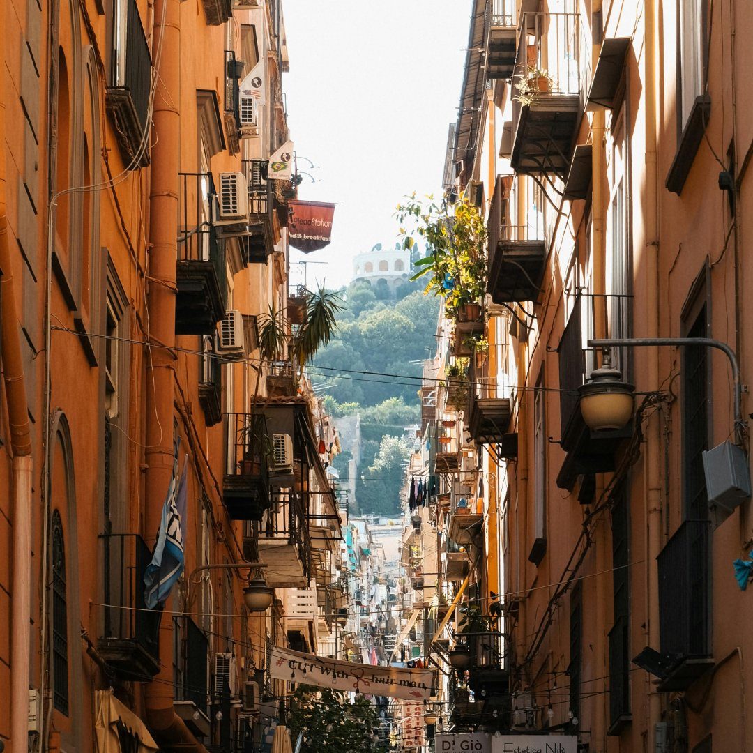 Narrow Spaccanapoli street in the Naples historic center seen between tall ochre buildings