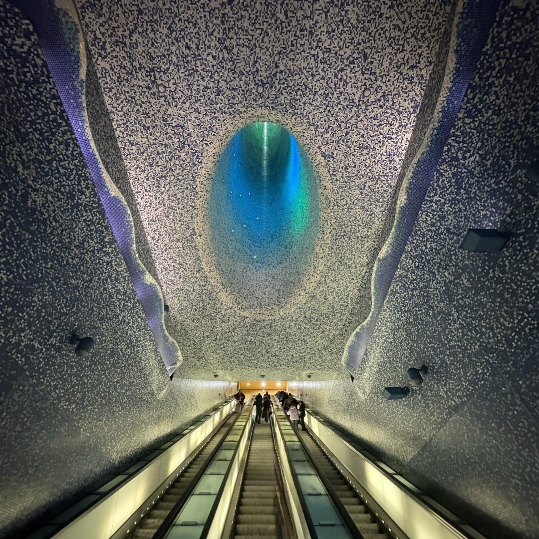 Blue mosaic light well above the escalators of Toledo art metro station in Naples